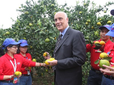 沃爾瑪中國公司事務高級副總裁博睿（中）考察大理項目基地，并同沃爾瑪員工志愿者一起幫助受助農(nóng)戶收獲成熟的柑橘。